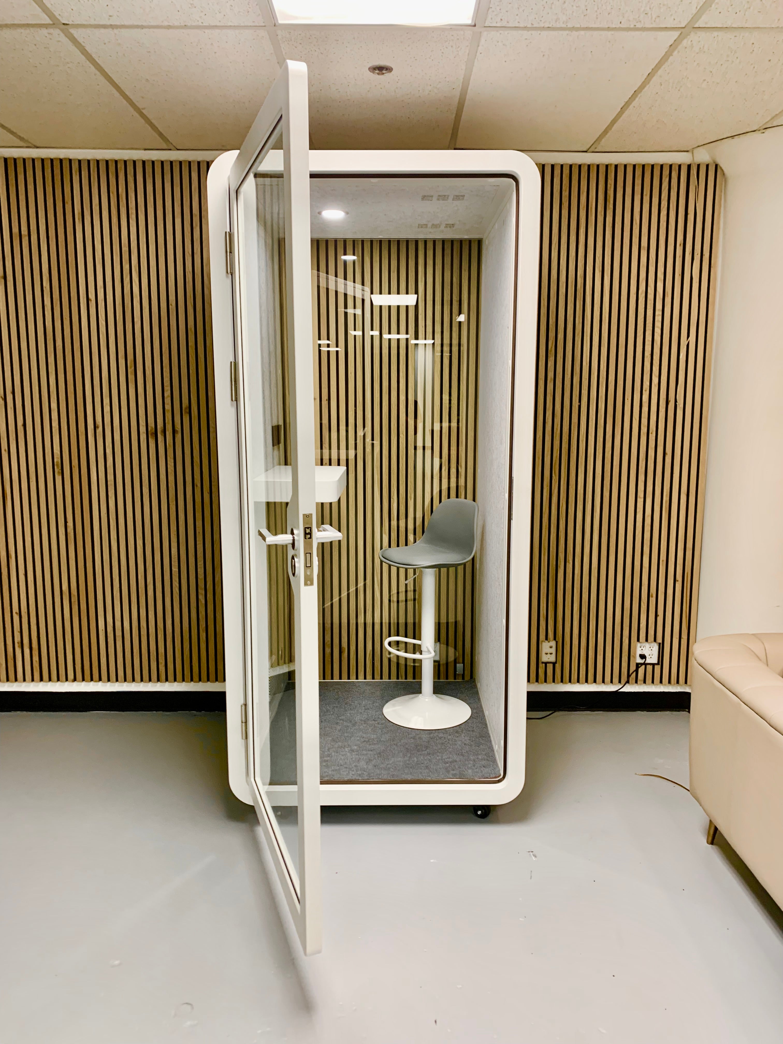 Solo study pod soundproof booth with wood panel backdrop